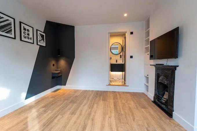 Renovated bedroom with fitted shelving, feature wall and ensuite doorway